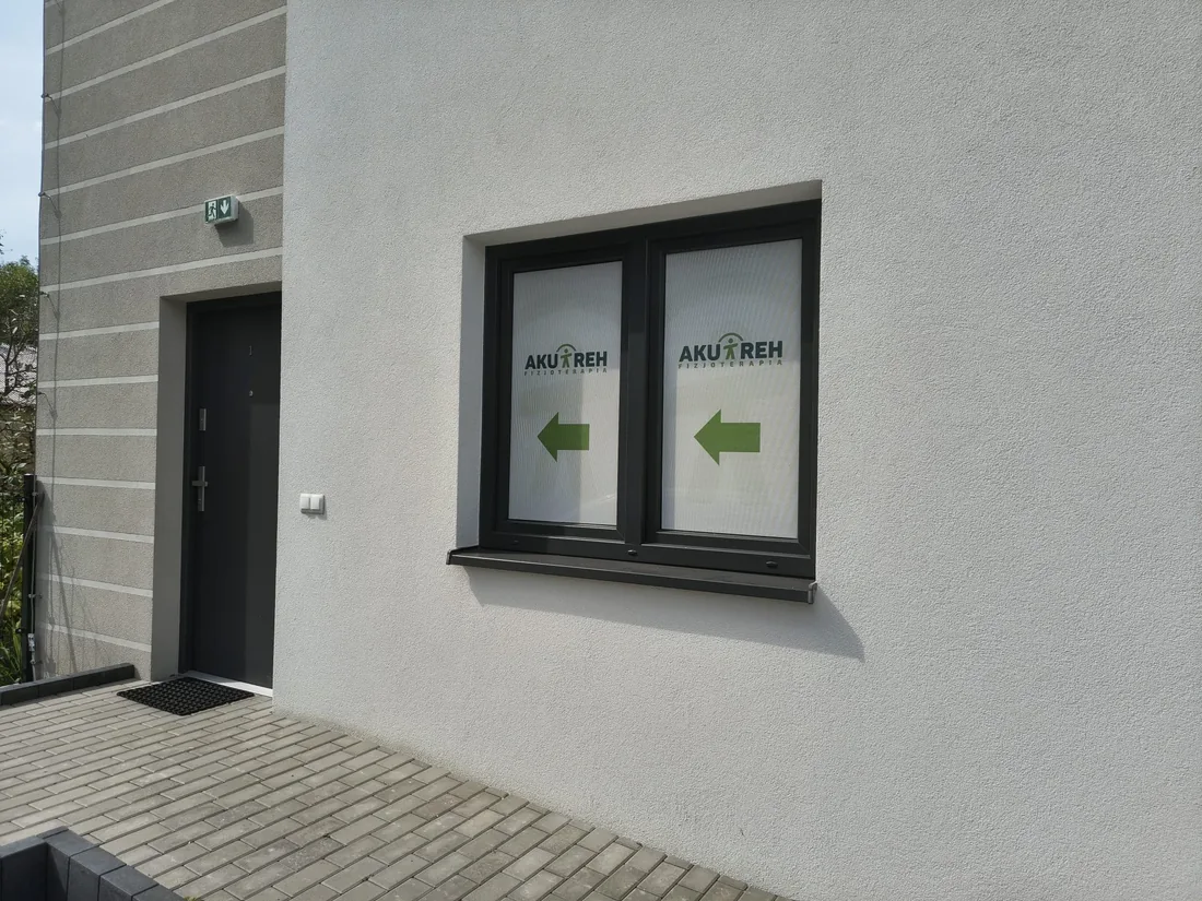 Wejście do gabinetu AKU-REH oznaczone zielonymi strzałkami na oknie